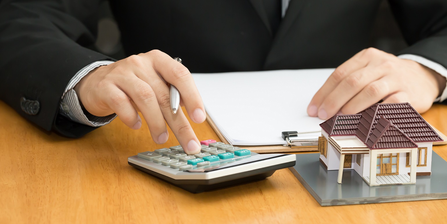 Man using a calculator for his mortgage insurance