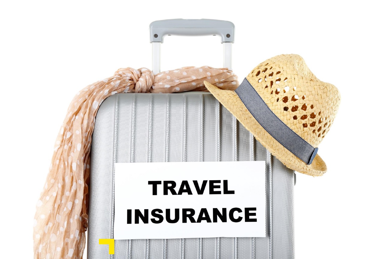 Suitcase with a summer hat and a label that read Travel Insurance